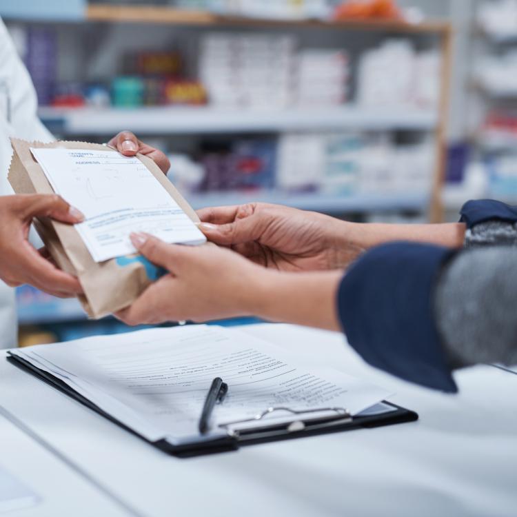 Pharmacist hands medicine to a patient.