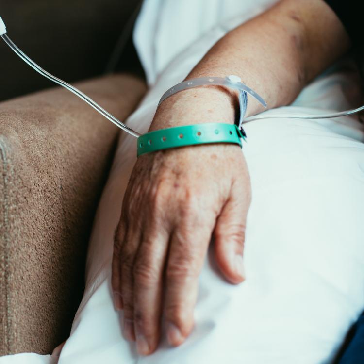 Hand of a patient who is seated, receiving an infusion